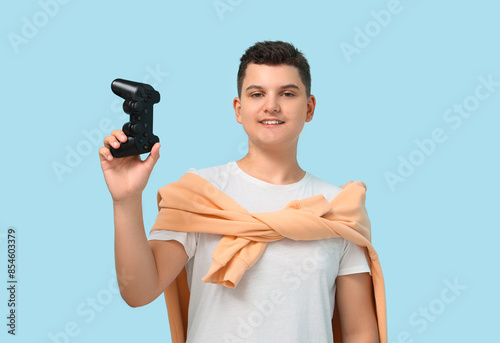 Teenage boy holding game pa...