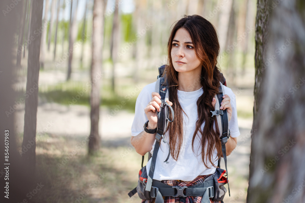 Relaxed female hiker enjoying walk in nature and looking away while having hiking Relaxed female hiker enjoying walk in nature and looking away while having hiking