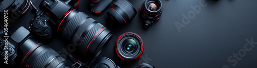Photographer's workplace with camera, camera and lens on a dark table background. Travel photography concept for hobby. Flat copy space, top view. Banner.