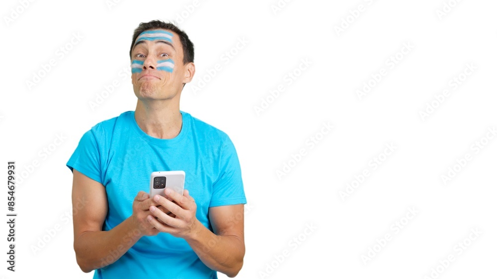 Argentina supporter looking at his mobile smiling and showing it. Argentina supporter looking at his mobile smiling and showing it.