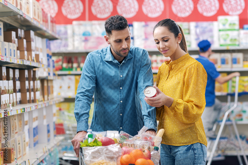 Happy couple doing grocery shopping at the supermarket photo