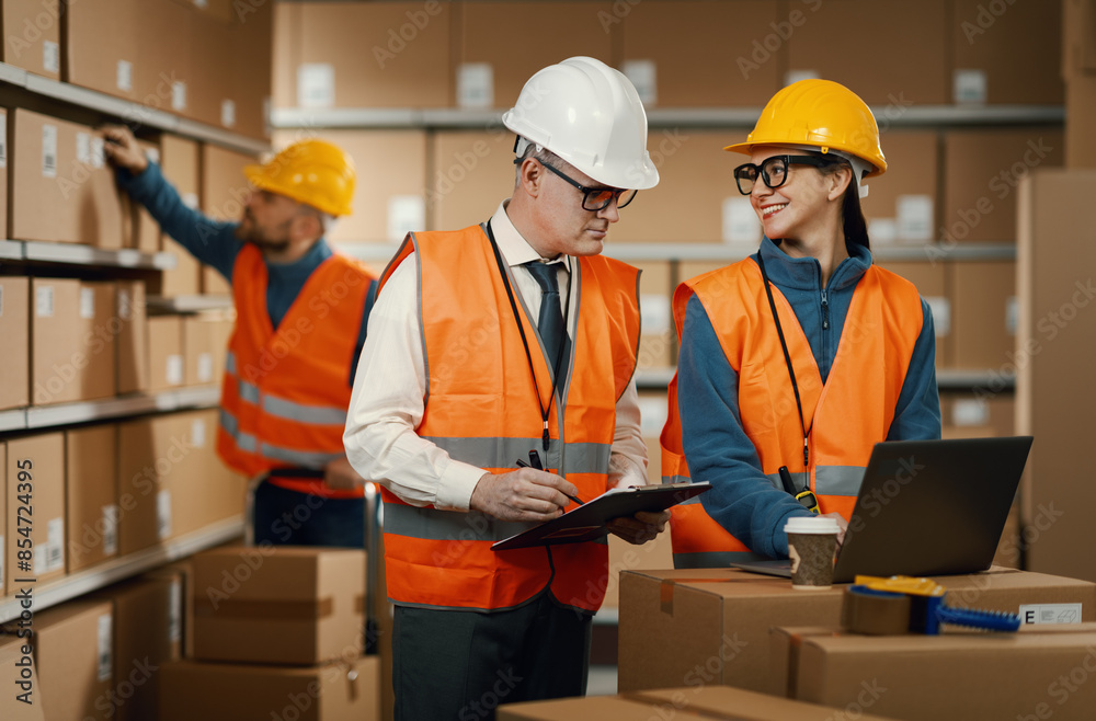 Warehouse workers checking orders on the laptop Warehouse workers checking orders on the laptop