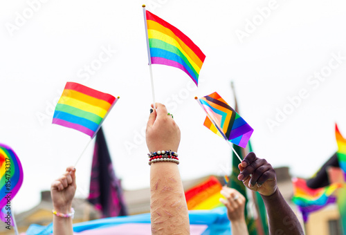 background with gender equality symbol. pride month celebration outdoor. on white raised hands up with rainbow flags