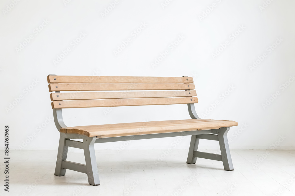 Wooden bench with gray metal legs in a white room Wooden bench with gray metal legs in a white room