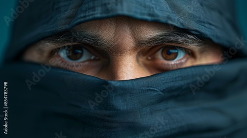 A man with brown eyes is wearing a black scarf