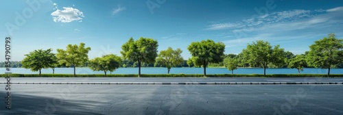 Empty asphalt road and green trees with blue sky background over the lake in summer, landscape nature view from side of empty street for product display.