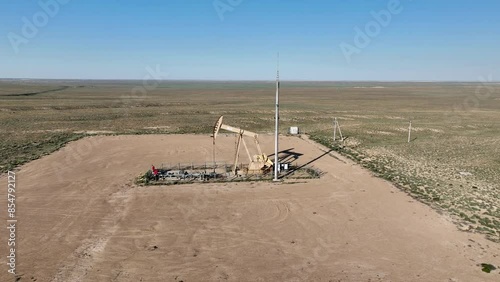 Warking oil well in the steppe on a sunny summer day.  photo