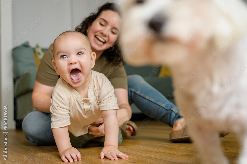 Joyful baby with mother encountering a dog at home Joyful baby with mother encountering a dog at home