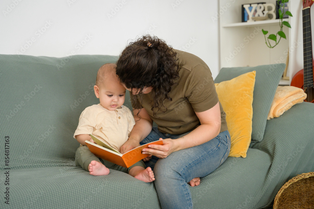 Mother reading to baby while sitting on a couch Mother reading to baby while sitting on a couch