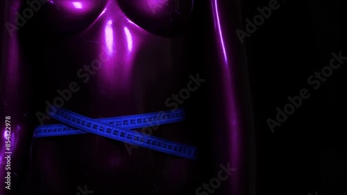 blue measuring tape around mannequin's waist with colored flashlights. RGB glowing lights
