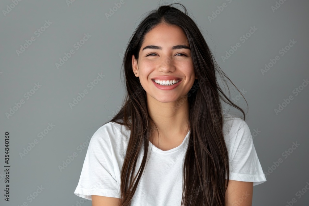 Portrait of a young latino femal smiling with long hair and white t shirt. Portrait of a young latino femal smiling with long hair and white t shirt.