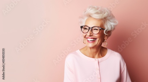 Elderly woman with short white hair smiling brightly, wearing a light pink sweater, against a soft pink background, horizontal, photo, copy space