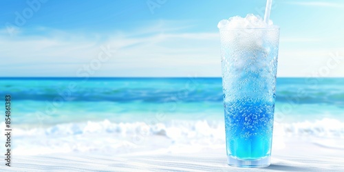 Refreshing blue cocktail drink on a tropical beach with ocean waves and blue sky