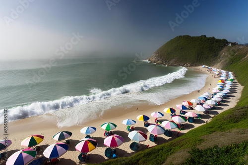 Aerial view of people on the beach, with colorful blankets and umbrellas