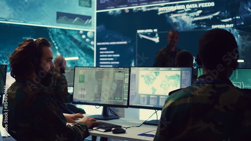 Commander communicating with allied forces and transmitting data from surveillance footage, coordinating joint operations and strategies to accomplish mission. Satellite radar operator. Camera B.