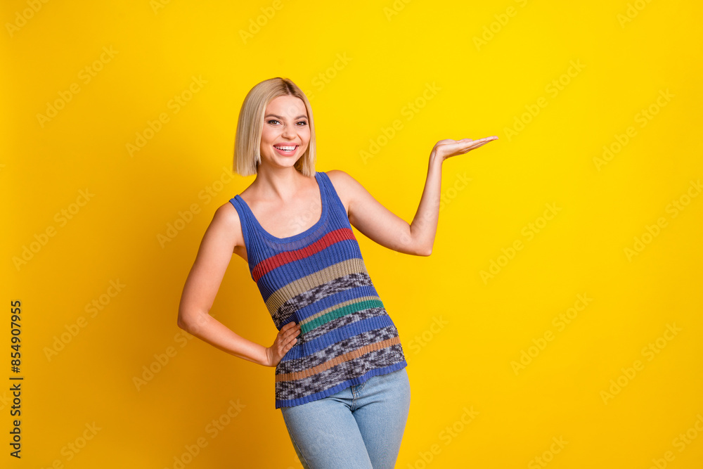 Photo portrait of young sweet beautiful woman in singlet holding absolutely new object empty space isolated on yellow color background Photo portrait of young sweet beautiful woman in singlet holding absolutely new object empty space isolated on yellow color background