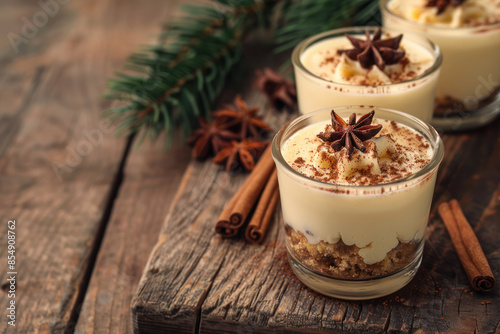 Closeup of a delicious eggnog dessert with star anise and cinnamon sticks on a rustic wooden table