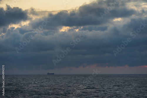 Fotografie Cargo ship in the Baltic sea with thunderclouds.