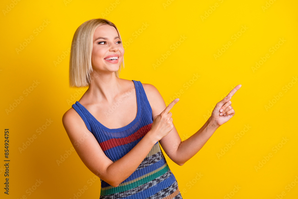 Photo of young sweet beautiful woman in singlet pointing fingers empty space gives advices and looking isolated on yellow color background Photo of young sweet beautiful woman in singlet pointing fingers empty space gives advices and looking isolated on yellow color background