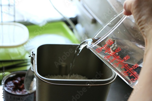 餅つき機に水を入れる