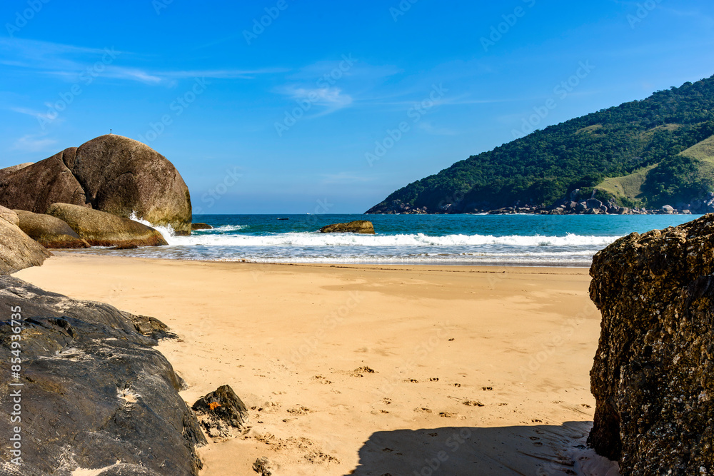 Bonete Beach on the island of Ilhabela seen through the rocks in the sand Bonete Beach on the island of Ilhabela seen through the rocks in the sand