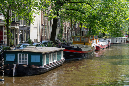Typical house boats parked at the canal of Amstel river in Amsterdam