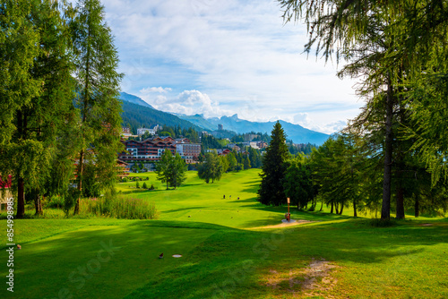 Wallpaper Mural Village with House and Hotel with Panoramic View over Mountain with Clouds and Golf Course in a Sunny Summer Day in Crans Montana, Valais, Switzerland. Torontodigital.ca
