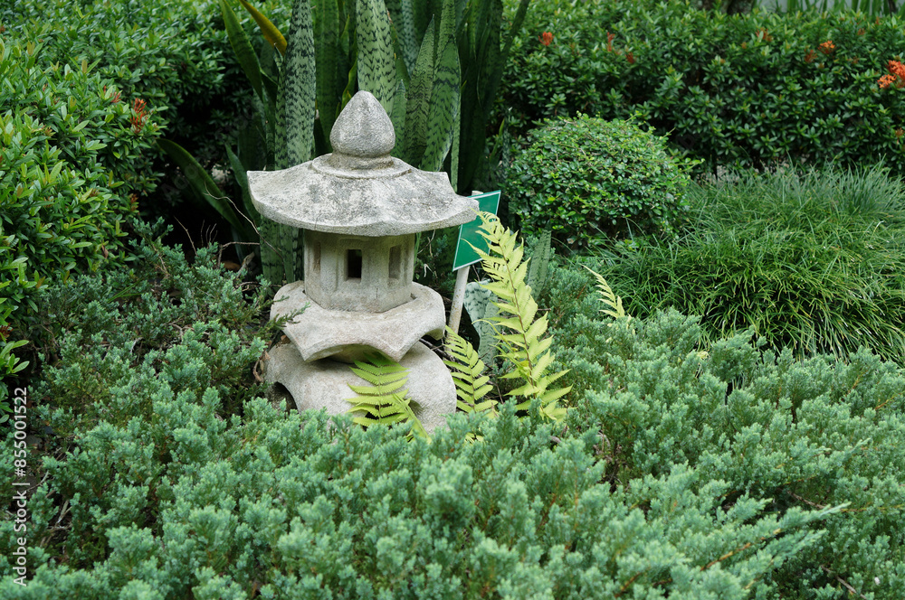 Stone pagoda statue in a lush garden Stone pagoda statue in a lush garden