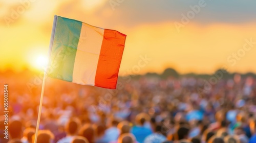 A large crowd is gathered at sunset, with the Italian flag prominently displayed in the foreground. #855003544