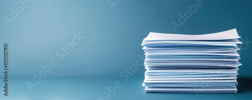 Stack of white papers organized on a blue background, representing office documentation, business, and information organization.