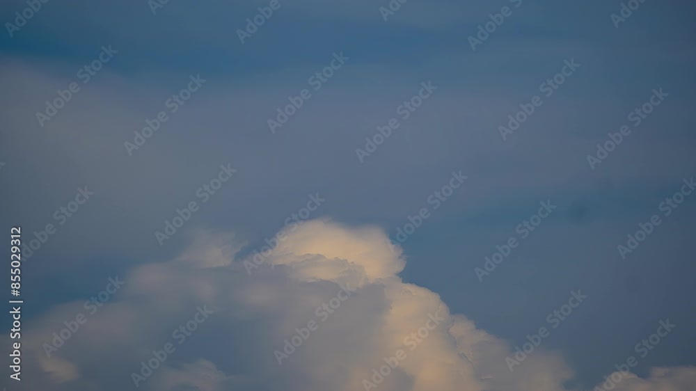 Clouds roll building and receeding into nothing on pastel sky glowing with a tint of yellow Clouds roll building and receeding into nothing on pastel sky glowing with a tint of yellow