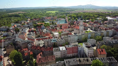 Historic buildings with red rooftops, lush greenery, and the surrounding scenic countryside with distant hills. Prudnik, Poland - Prudnik, Polska photo