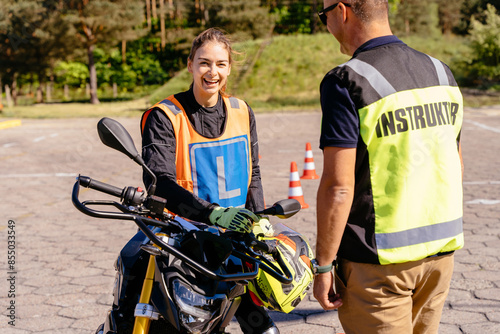 Photos Close up of driving male instructor showing motorcycle commands and dashboard to the inexperienced female student