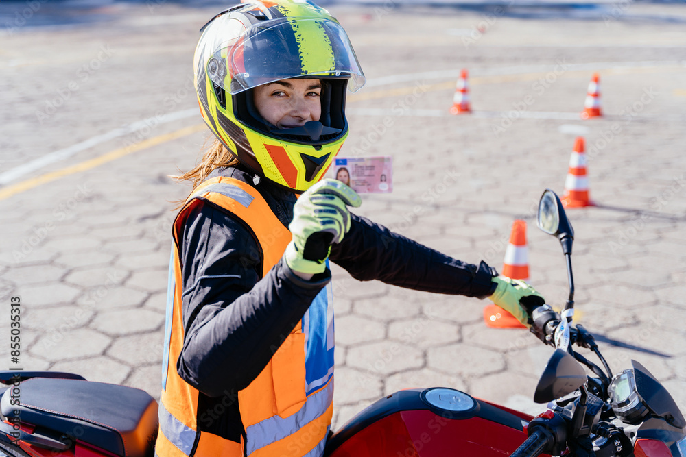Student showing motorcycle driving license as successfully finished riding lessons. Student showing motorcycle driving license as successfully finished riding lessons.