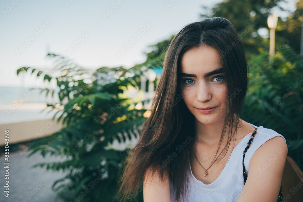 A woman with long hair is sitting on a bench in a park A woman with long hair is sitting on a bench in a park