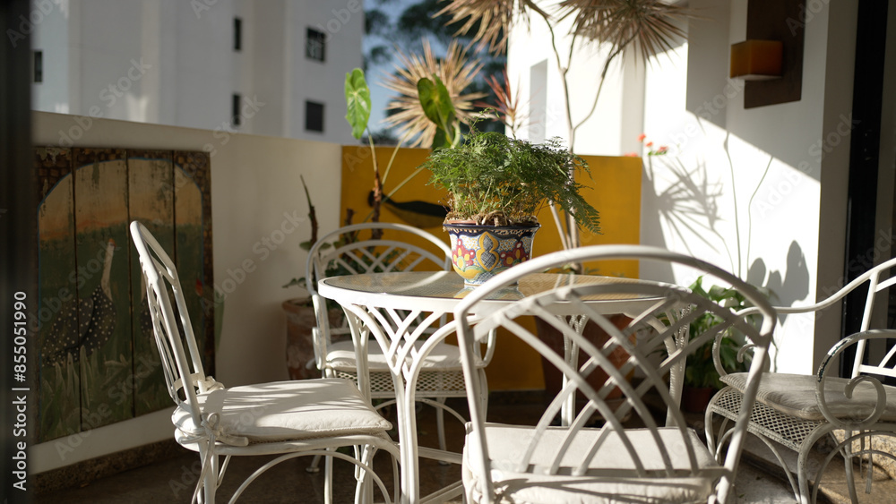 Fototapeta premium Tranquil Outdoor Patio Setting with White Wrought Iron Furniture and Decorative Plants