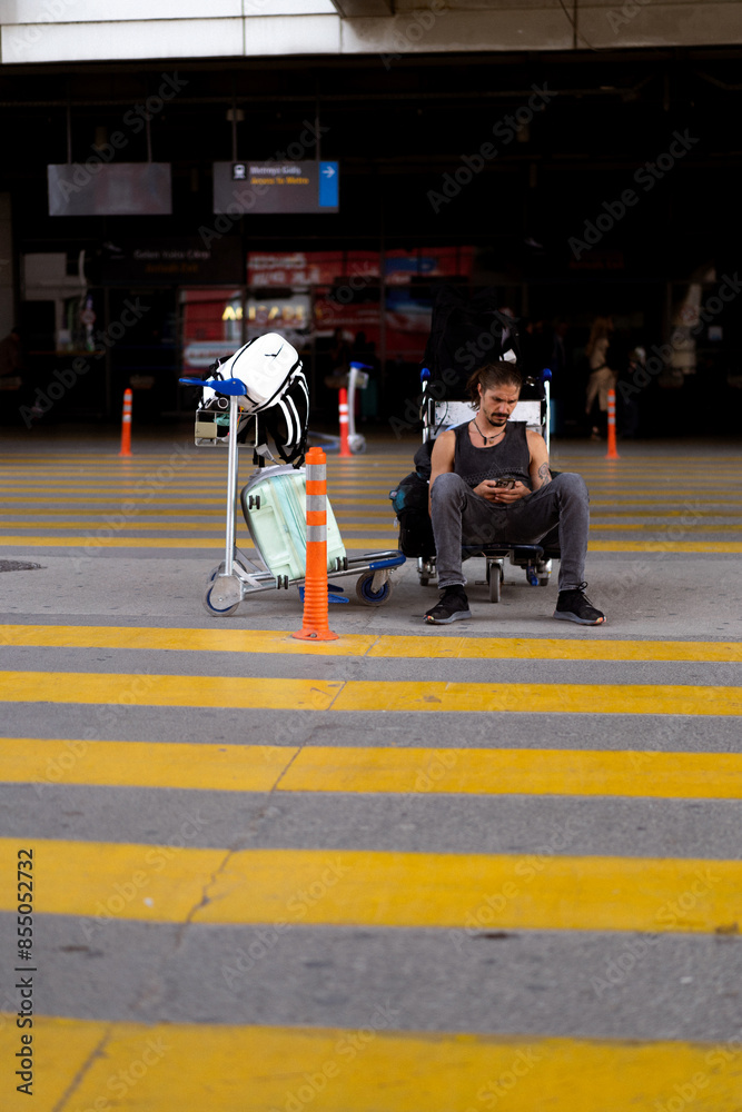 Fototapeta premium Man traveler at airport calls taxi through application on phone.