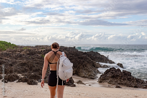 Woman hiking along a rocky beach in Hawaii. photo