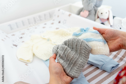 Mother Choosing Hand-Knit Wool Hat for Baby