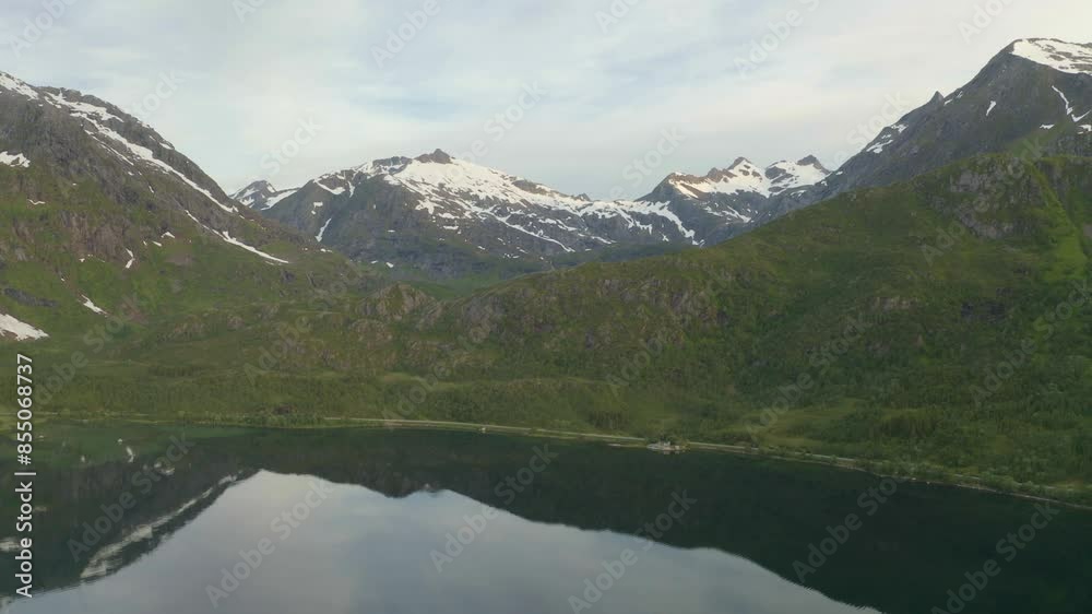 Snow-covered mountain reflected in lake, Lofoten, Northern Norway. Snow-covered mountain reflected in lake, Lofoten, Northern Norway.