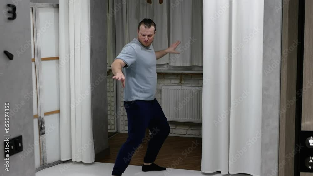 A man practices his dancing skills at home. A man dances in the apartment. A man practices his dancing skills at home. A man dances in the apartment.