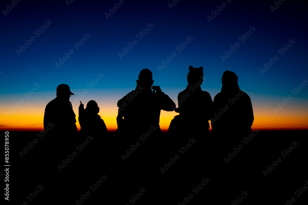 Fototapeta premium Adventure Friendship at Sunset: Silhouetted Group of Friends Embrace Nature's Beauty, Summer Journey of Hiking and Trekking Together in Majestic Mountain Landscapes, Enjoying Outdoor Activities
