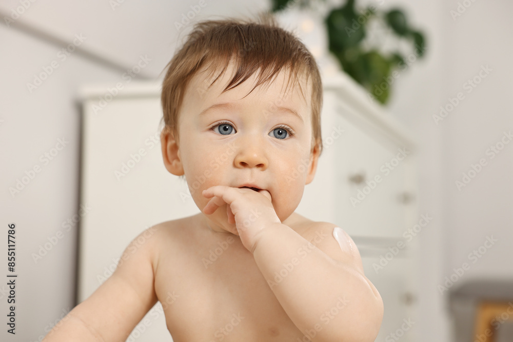 Cute little baby with moisturizing cream on body indoors Cute little baby with moisturizing cream on body indoors