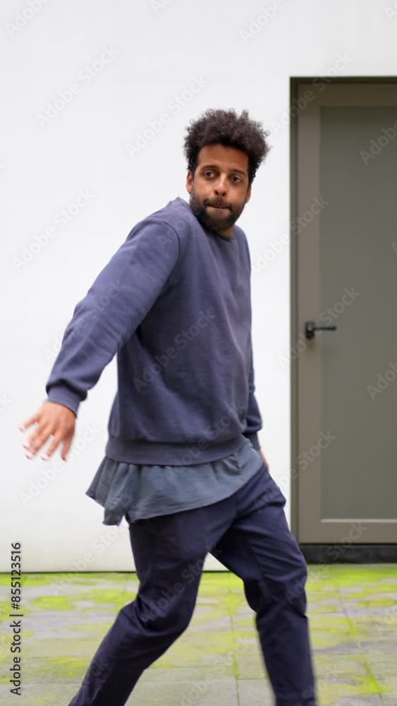 Black ethnic man dancing urban dance in the city in a blue sweatshirt is running and holding a skateboard. Concept of energy and excitement, as the man is enjoying his time outdoors Black ethnic man dancing urban dance in the city in a blue sweatshirt is running and holding a skateboard. Concept of energy and excitement, as the man is enjoying his time outdoors