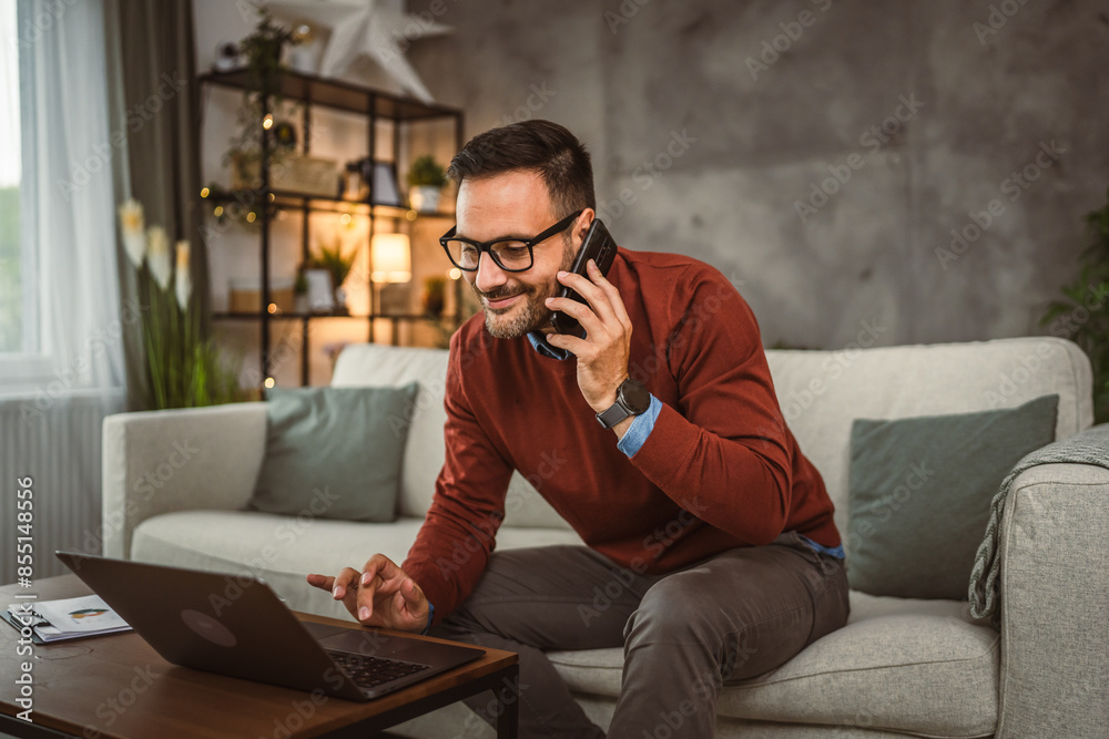 Fototapeta premium Adult businessman work from home and talk on mobile phone