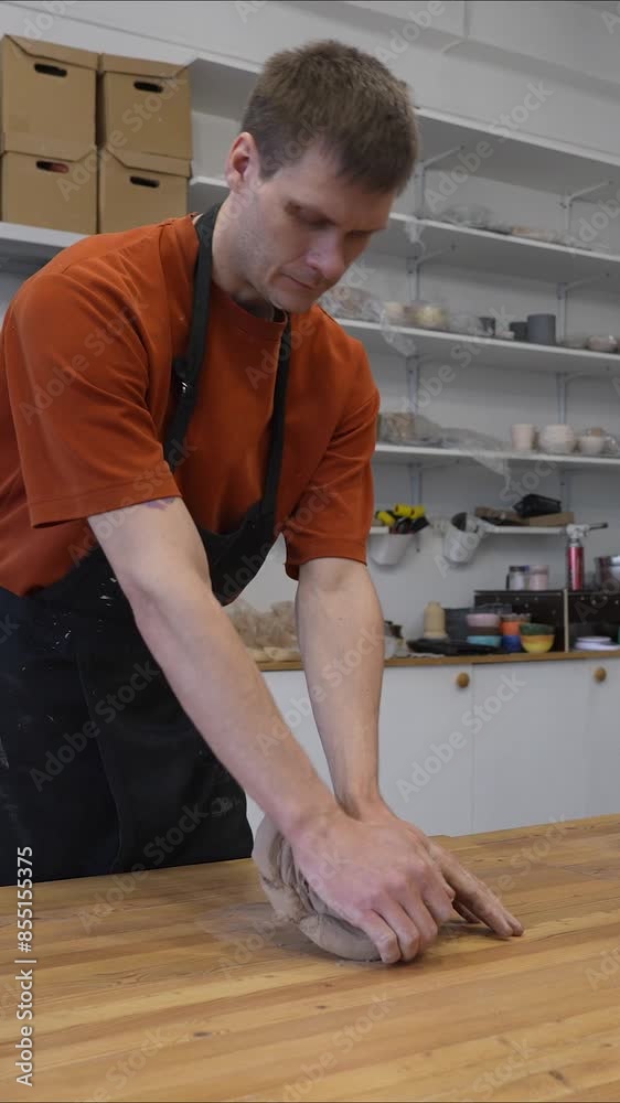 A potter kneads clay before using it in the workshop. Close-up of a man's hands. Vertical video. A potter kneads clay before using it in the workshop. Close-up of a man's hands. Vertical video.