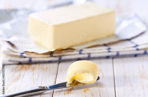 Принти на полотні piece butter and knife on a white wooden table, selective focus.