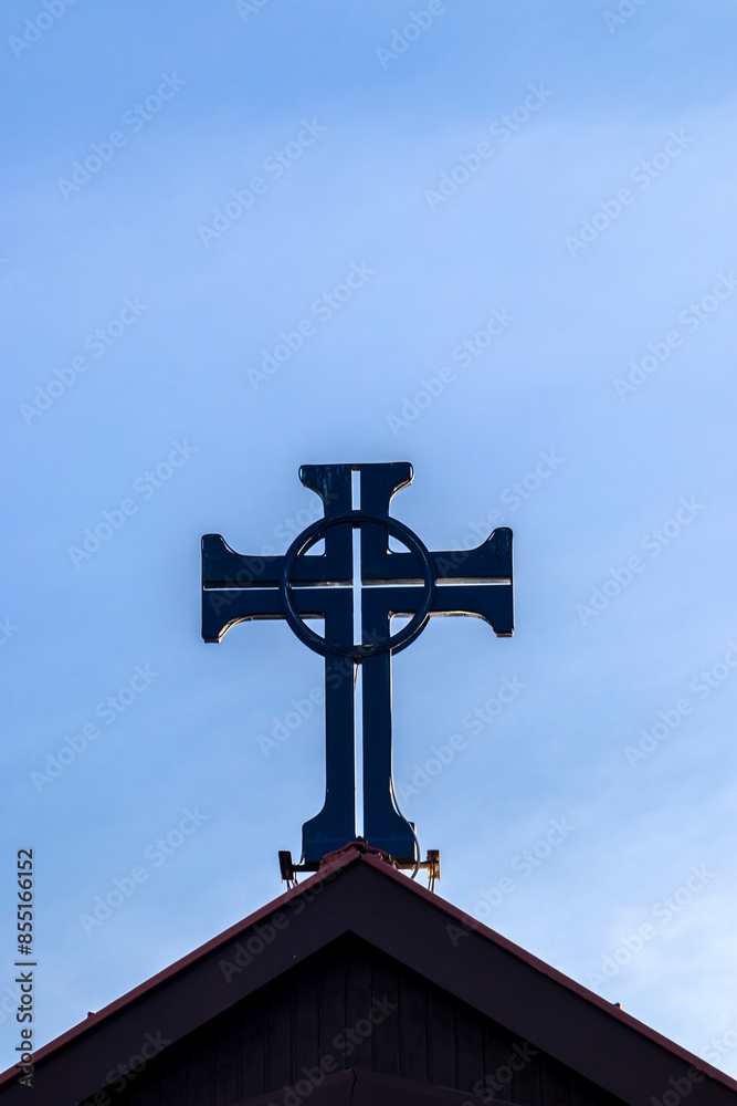 Crucifix on top tower of chapel in Brazil, with blue sky background Crucifix on top tower of chapel in Brazil, with blue sky background