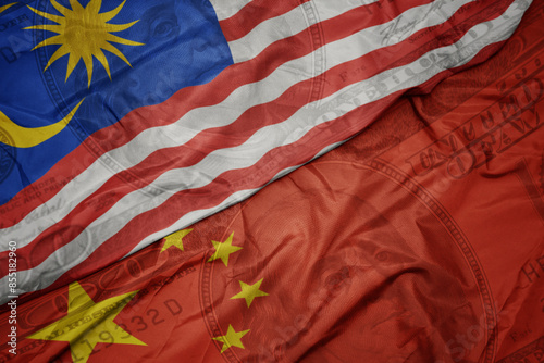 Photography waving colorful flag of malaysia and national flag of china on the dollar money background