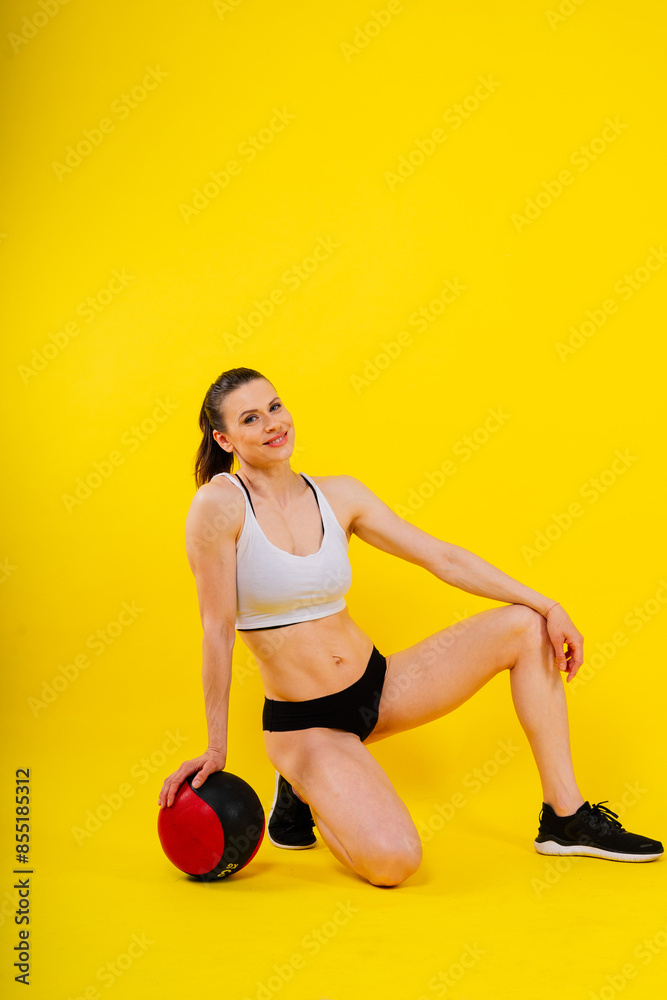 Fitness happy fit woman standing holding a medicine ball. Slim caucasian cross fit woman with fitness ball Fitness happy fit woman standing holding a medicine ball. Slim caucasian cross fit woman with fitness ball